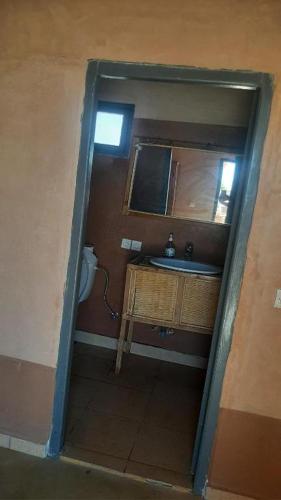 a small bathroom with a sink and a mirror at Maison d'hôtes chez l'habitant Asfalou in Ouarzazate