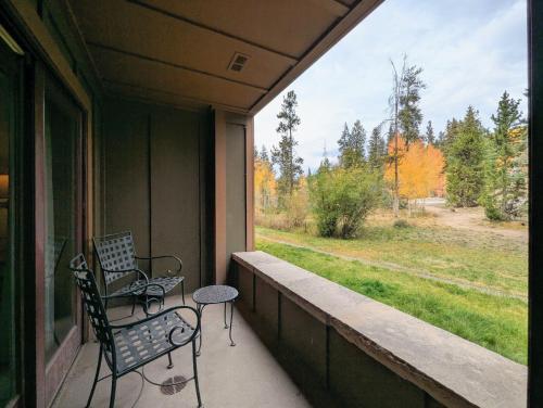 a porch with two chairs and a table and a window at Springs 8803 by SummitCove Lodging in Colorado in Keystone