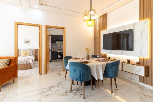 a dining room with a table and blue chairs at Fun and Sun - Appartement de luxe - Dahomey Beach - Bouznika in Bouznika
