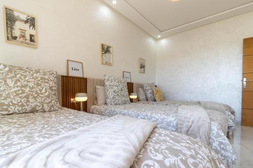 a bedroom with two beds and two lamps at Fun and Sun - Appartement de luxe - Dahomey Beach - Bouznika in Bouznika