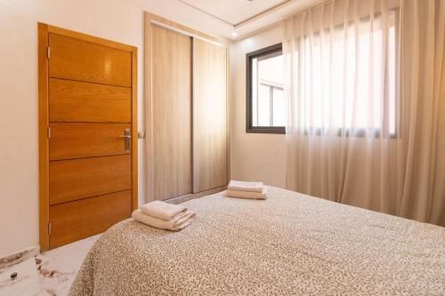 a bedroom with a bed with two towels on it at Fun and Sun - Appartement de luxe - Dahomey Beach - Bouznika in Bouznika