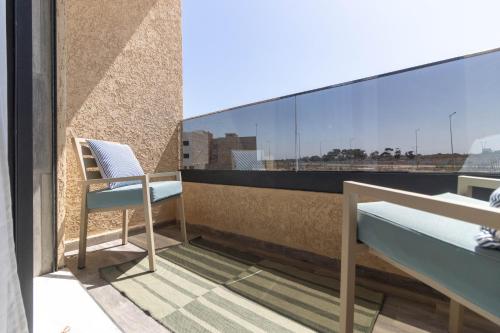 a balcony with a chair and a view of the city at Fun and Sun - Appartement de luxe - Dahomey Beach - Bouznika in Bouznika