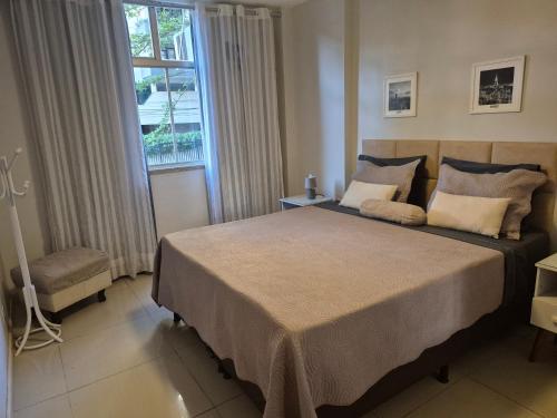 a bedroom with a large bed and a window at Apartamento em Niterói Excelente Localização - Boa Viagem in Niterói