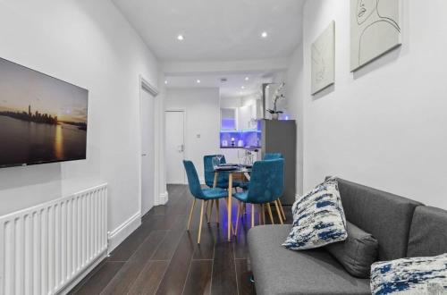 a living room with a couch and a table and chairs at Amazing 1 Bedroom Flat in Central London in Moffat