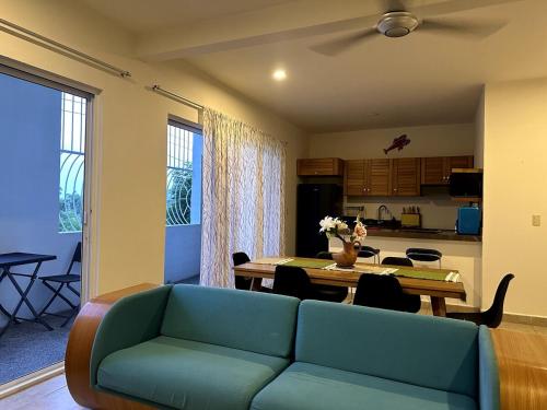 a living room with a blue couch and a table at Terraza Carrizalillo in Puerto Escondido