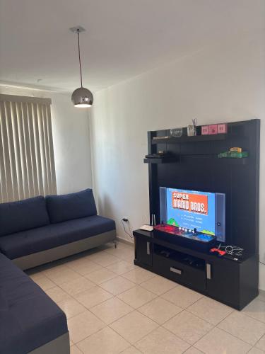 a living room with a couch and a flat screen tv at Casa completa y equipada 4 habitaciones 6 camas asador y juguetes para niños A 10 minutos de parques industriales, clínicas 71 y 16 del IMSS y del ISSSTE juegos Arcade in Torreón