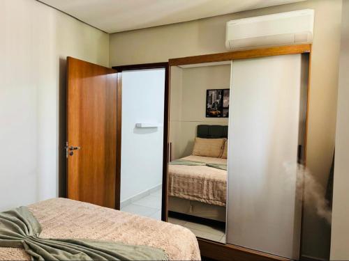 a bedroom with a sliding glass door with a bed at Residencial Leste Universitário in Goiânia