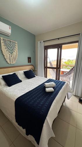 a bedroom with a large bed with blue sheets and a window at Apartamento - Garden Flat Mar Azul in Taíba