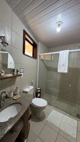 a bathroom with a shower and a toilet and a sink at Apartamento - Garden Flat Mar Azul in Taíba