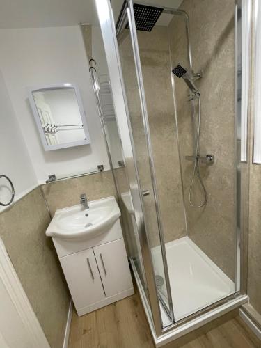 a bathroom with a shower and a sink at Woodlands in Wythenshawe