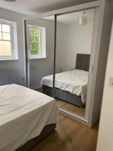 a mirror in a bedroom with two beds and a window at Woodlands in Wythenshawe