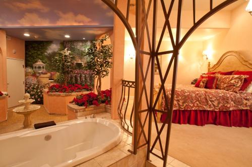 a large bathroom with a tub and a bed at Destinations Inn Theme Rooms in Idaho Falls