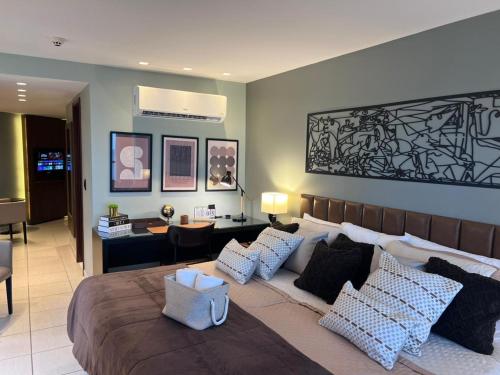 a bedroom with a large bed with pillows at Frente Mar - Beach Class Internacional - Flat Boa Viagem in Recife