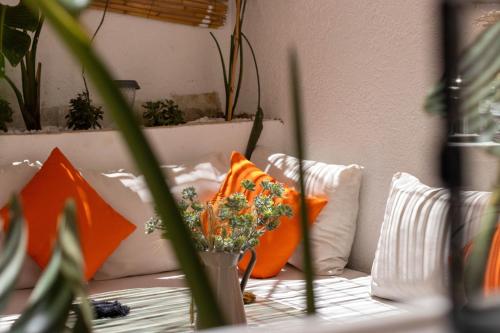 a couch with orange pillows and a vase of flowers at Charm and Calm - Superbe appartement de luxe - Dahomy Beach - Bahia Beach in Bouznika
