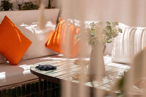 a vase with flowers on a table on a couch at Charm and Calm - Superbe appartement de luxe - Dahomy Beach - Bahia Beach in Bouznika