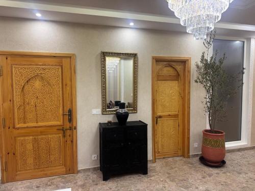 a room with two wooden doors and a mirror at Soho elegance near beach & center 2 bedrooms terrasse in Essaouira