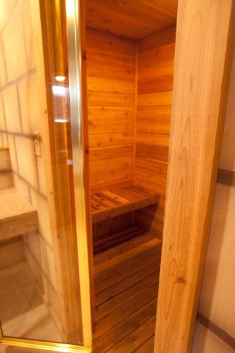 a small wooden sauna with a glass door at Destinations Inn Theme Rooms in Idaho Falls