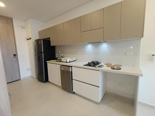 eine Küche mit Herd und Kühlschrank in der Unterkunft Escápate y convierte tus vacaciones en recuerdos in Santa Marta