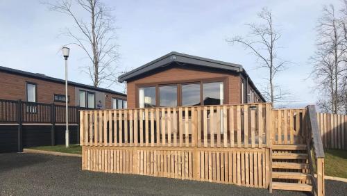 a small house with a wooden fence in front of it at 47 Northwood, Lilliardsedge in Jedburgh