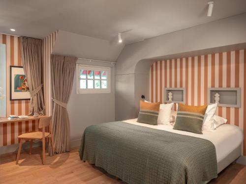 a bedroom with a large bed and a window at Villa des Rêves - Padel, Piscine, Jacuzzi, proche Deauville in Villers-sur-Mer