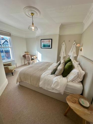 a bedroom with a large bed and a table at High spec 4 bed Victorian house in Surbiton