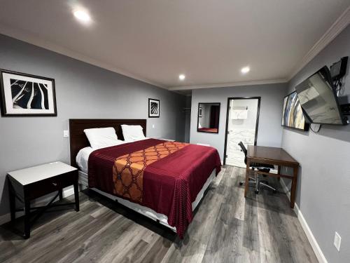 a bedroom with a bed and a desk and a computer at Aqua Inn Motel in El Monte