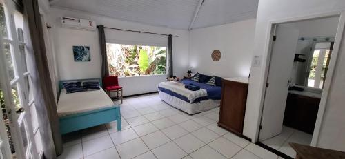 Habitación con cama, sofá y ventana en Apartamento dos coqueiros Búzios, en Búzios