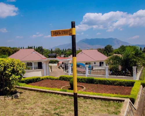 a street sign on a pole in front of a house at Boma Hill Residence Apartments by Monalisa in Morogoro