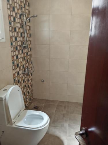 Un baño con inodoro blanco y ducha. en Bawsher hay al baydah villa, en Mascate
