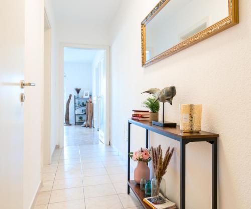 a hallway with a table and a mirror on the wall at OG2 L City Wohnung mit Balkon 15min bis Salzburg in Freilassing