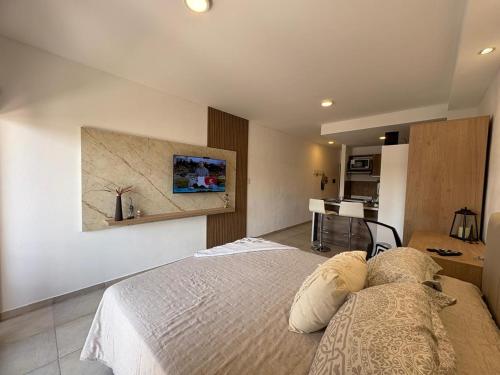 1 dormitorio con 1 cama y cocina en el fondo en suite urquiza, en Paraná