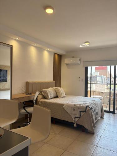 a bedroom with a bed and a desk and a desk at suite urquiza in Paraná