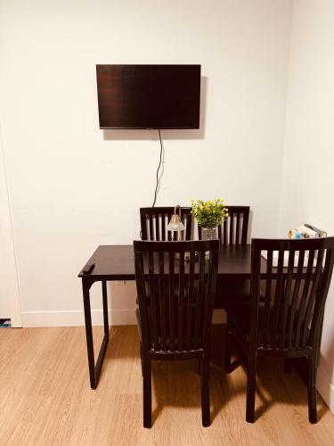 a dining room table with two chairs and a television at Sweet home 2 bedroom suite in Surrey