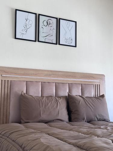 a bed with four pictures on the wall above it at La Pause Comfort style in the center in Temara