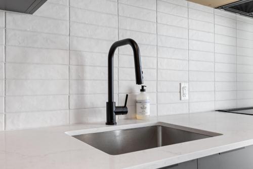 a kitchen sink with a black faucet at Brand new suite downtown Kelowna - walk everywhere! in Kelowna