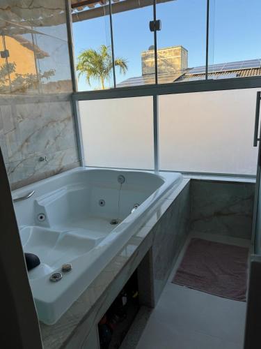 una vasca bianca in un bagno con finestra di Casa de praia a Guarapari