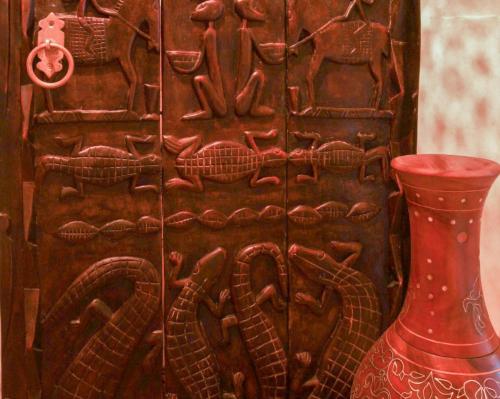 a wooden door with a red vase next to it at Dar Rio Oro in Dakhla