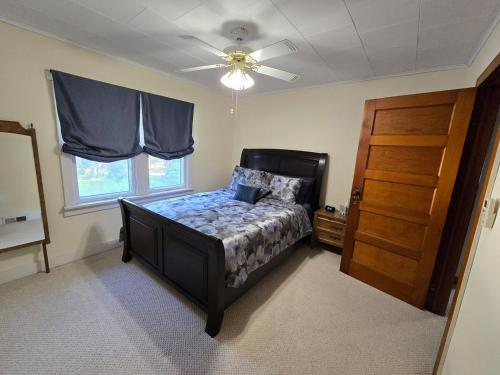 une chambre avec un lit et un ventilateur de plafond dans l'établissement Elena's Lake Cottage - A Cozy Lake Getaway, à Lake Geneva