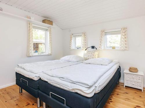 a large bed in a room with two windows at 6 person holiday home in Thisted in Thisted