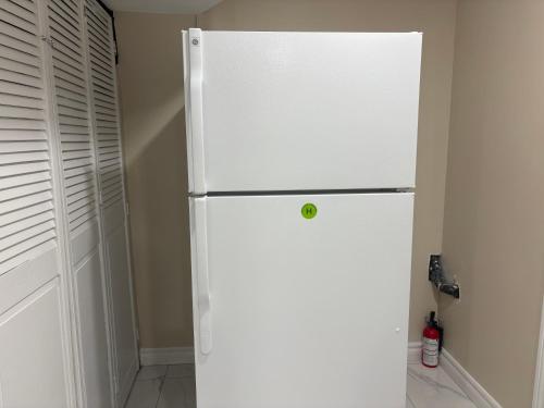 a white refrigerator freezer in a kitchen next to a door at Vita House near Downsview and Yorkdale Shopping Center in Toronto