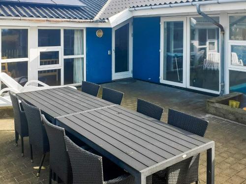 a wooden table and chairs on a patio at 12 person holiday home in Vestervig-By Traum in Vestervig