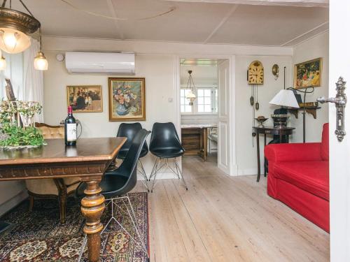 a living room with a table and a red couch at 4 person holiday home in Tønder in Tønder