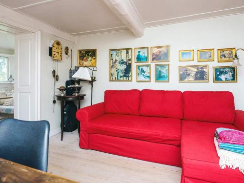 a red couch in a living room with pictures on the wall at 4 person holiday home in Tønder in Tønder