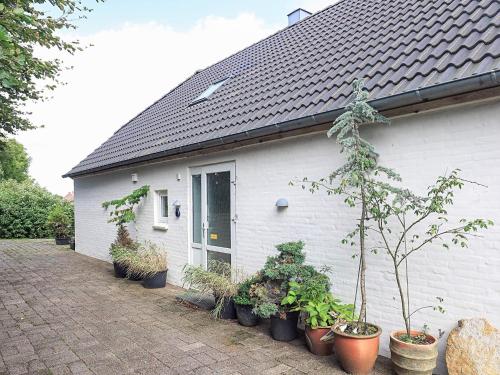 a white house with potted plants in front of it at 6 person holiday home in Thisted in Thisted