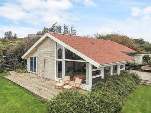 a house with a deck with two chairs and a roof at 4 person holiday home in Struer in Struer