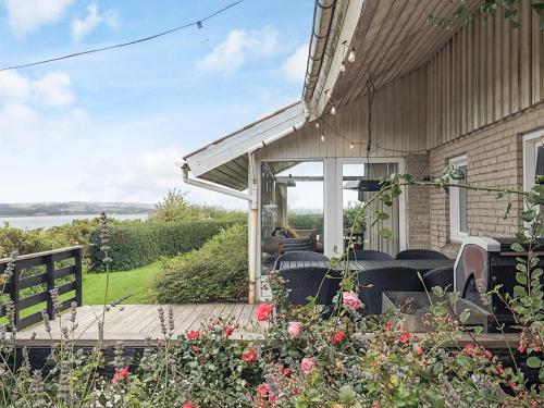a porch of a house with chairs and flowers at 4 person holiday home in Struer in Struer