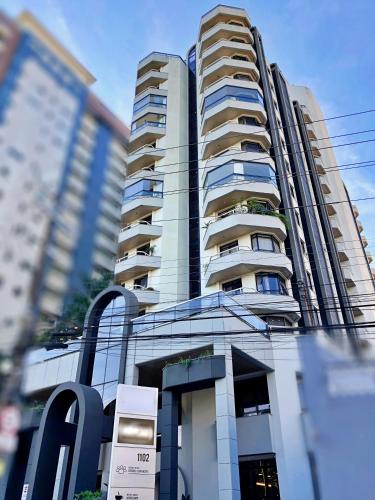 a tall building with a sign in front of it at Central Park Flat Residence - Home Time in Florianópolis