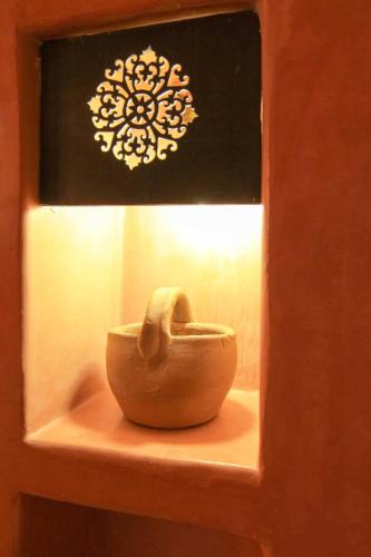 a small bowl sitting on a shelf with a light at Dar Rio Oro in Dakhla