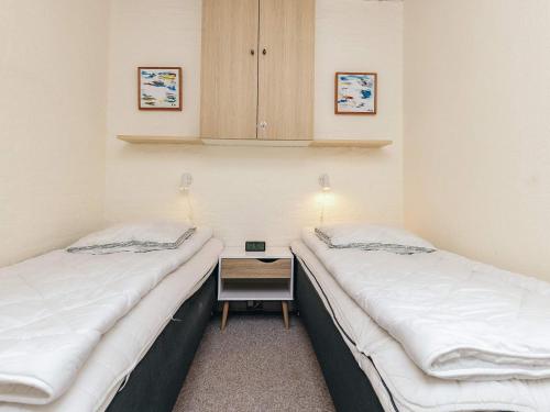 two twin beds in a room with a night stand at 4 person holiday home in Vestervig-By Traum in Vestervig