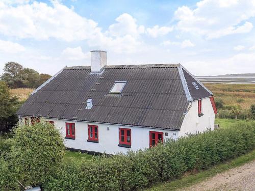 a white house with red windows and a black roof at Panoramic View Fisherman's House - By Traum Ferienwohnungen in Vesløs